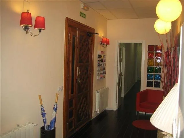 Well-lit welcoming corridor with wooden entrance door